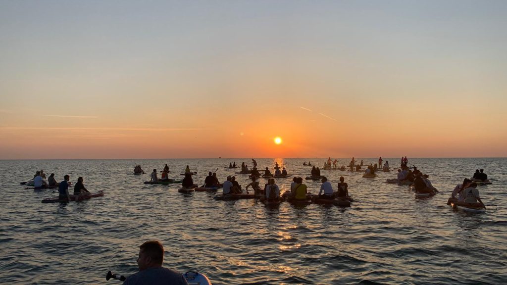 Il gruppo dei Giovani Soci RomagnaBanca osserva l'alba dalle tavole SUP a Cesenatico