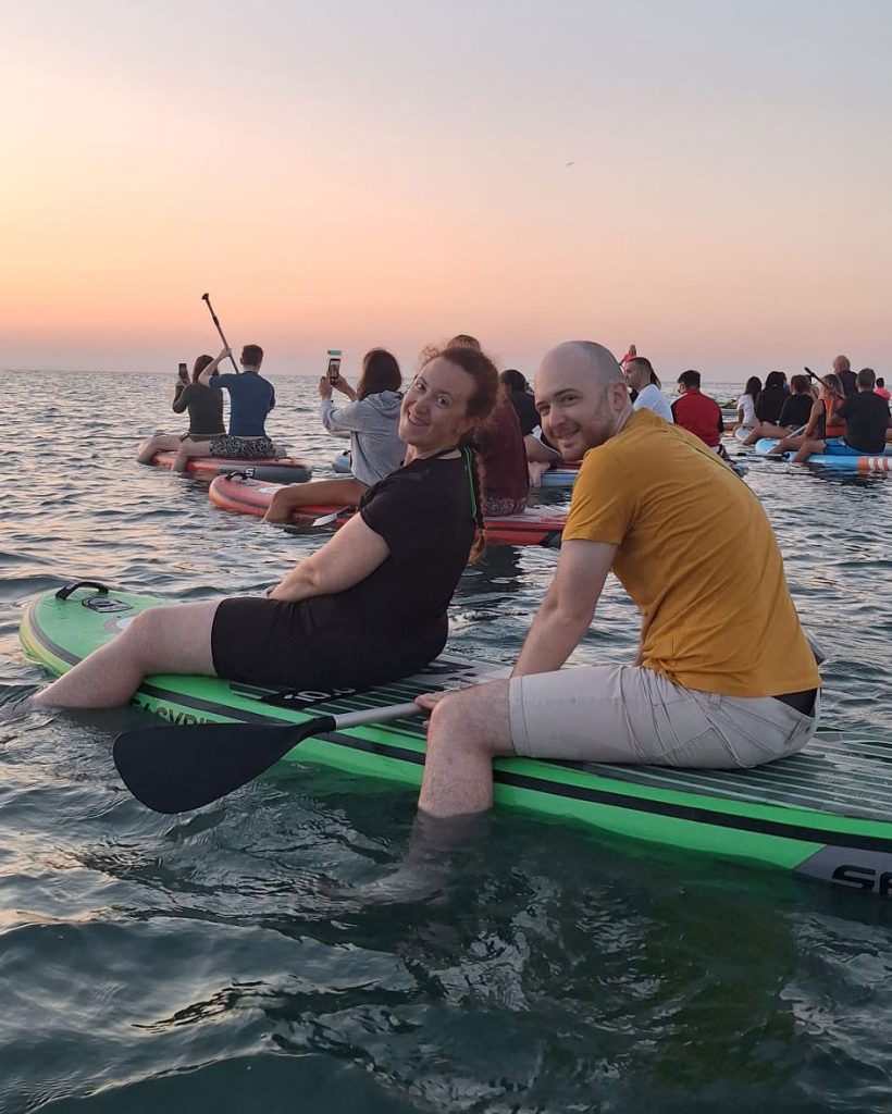 Due Giovani Soci RomagnaBanca sulla tavola SUP durante l'alba a Cesenatico