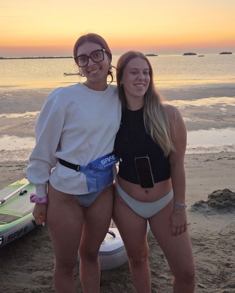 Due Giovani Socie RomagnaBanca sorridono in spiaggia a Cesenatico dopo l'uscita in SUP