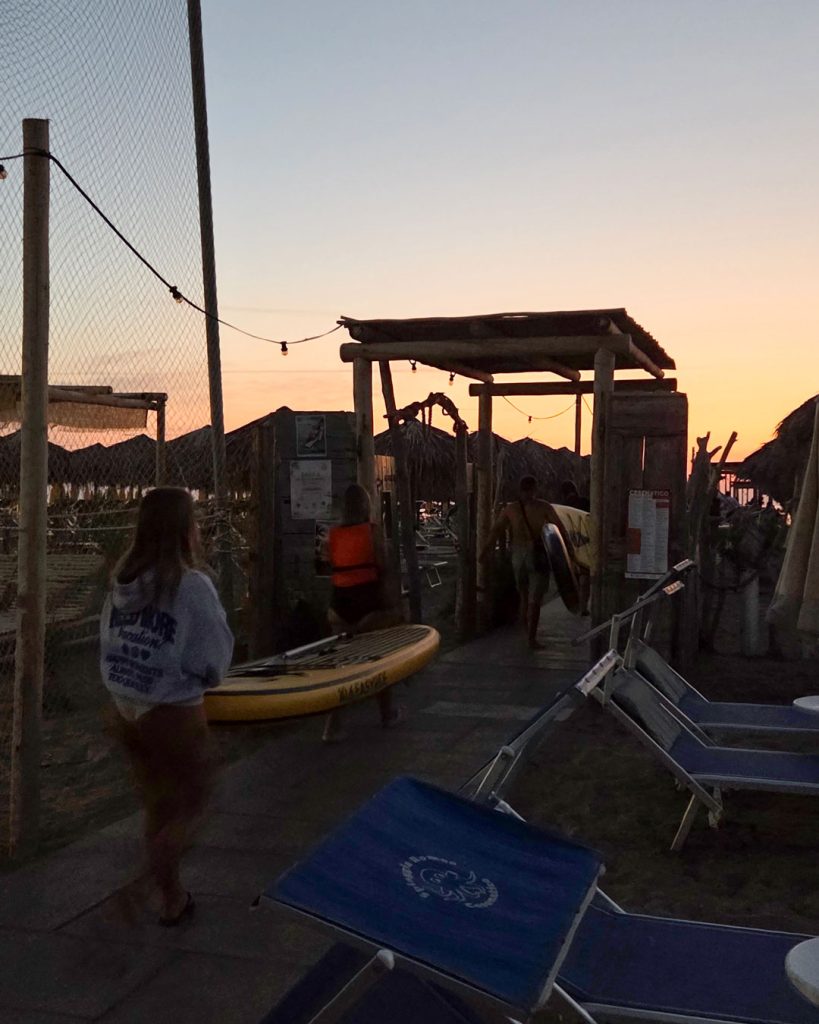 Giovani Soci RomagnaBanca si dirigono verso il mare con le tavole SUP all'alba a Cesenatico