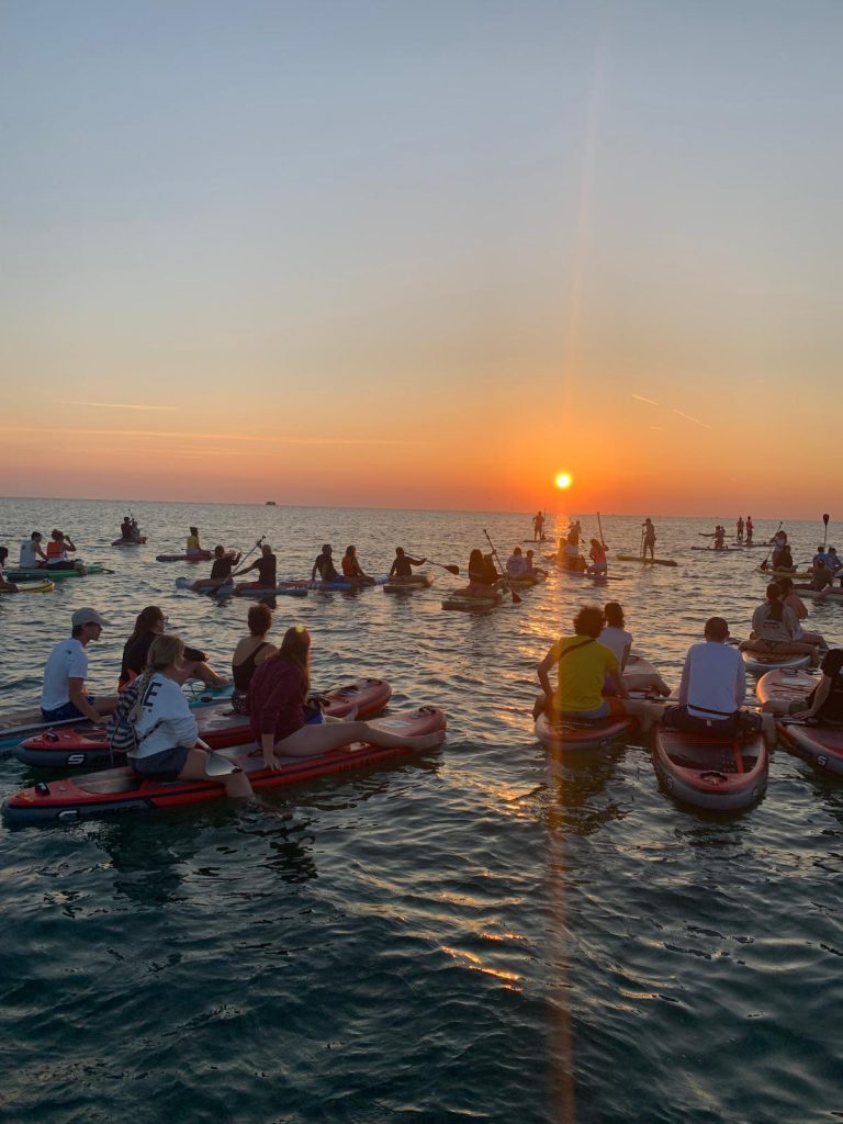 Il riflesso del sole nascente sul mare durante l'alba in Sup dei Giovani Soci RomagnaBanca a Cesenatico