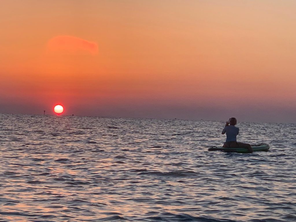 Un Giovane Socio RomagnaBanca fotografa il sole che sorge dal mare durante l'alba in Sup a Cesenatico