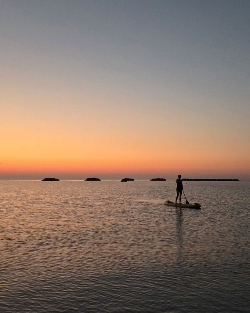 Un Giovane Socio in equilibrio sulla tavola SUP al largo di Cesenatico durante l'alba