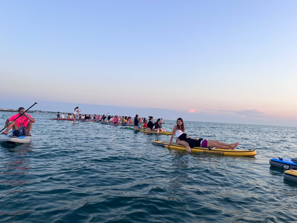 Le tavole SUP dei Giovani Soci RomagnaBanca allineate in mare durante l'alba a Cesenatico