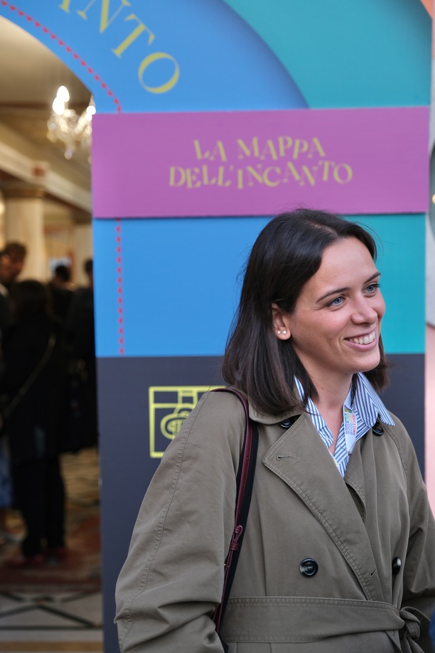 Giovane socia davanti al portale all'ingresso della Mappa dell'incanto la mostra del forum giovani soci bcc a l'aquila
