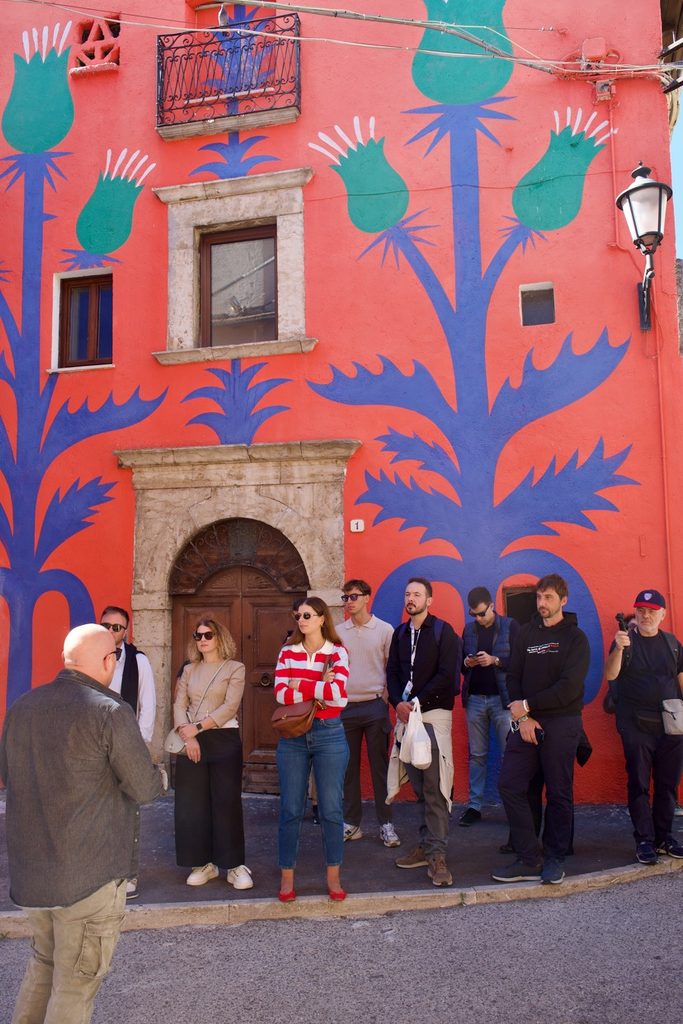 Giovani Soci e Socie BCC in visita ad Aielli davanti al murale di Agostino Iacurci "Cardi" 