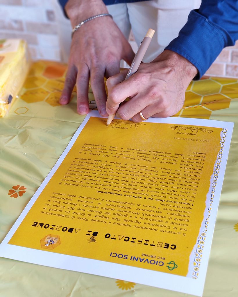 Firma sul certificato di adozione di un'arnia da parte del Gruppo Giovani Soci BCC Erchie